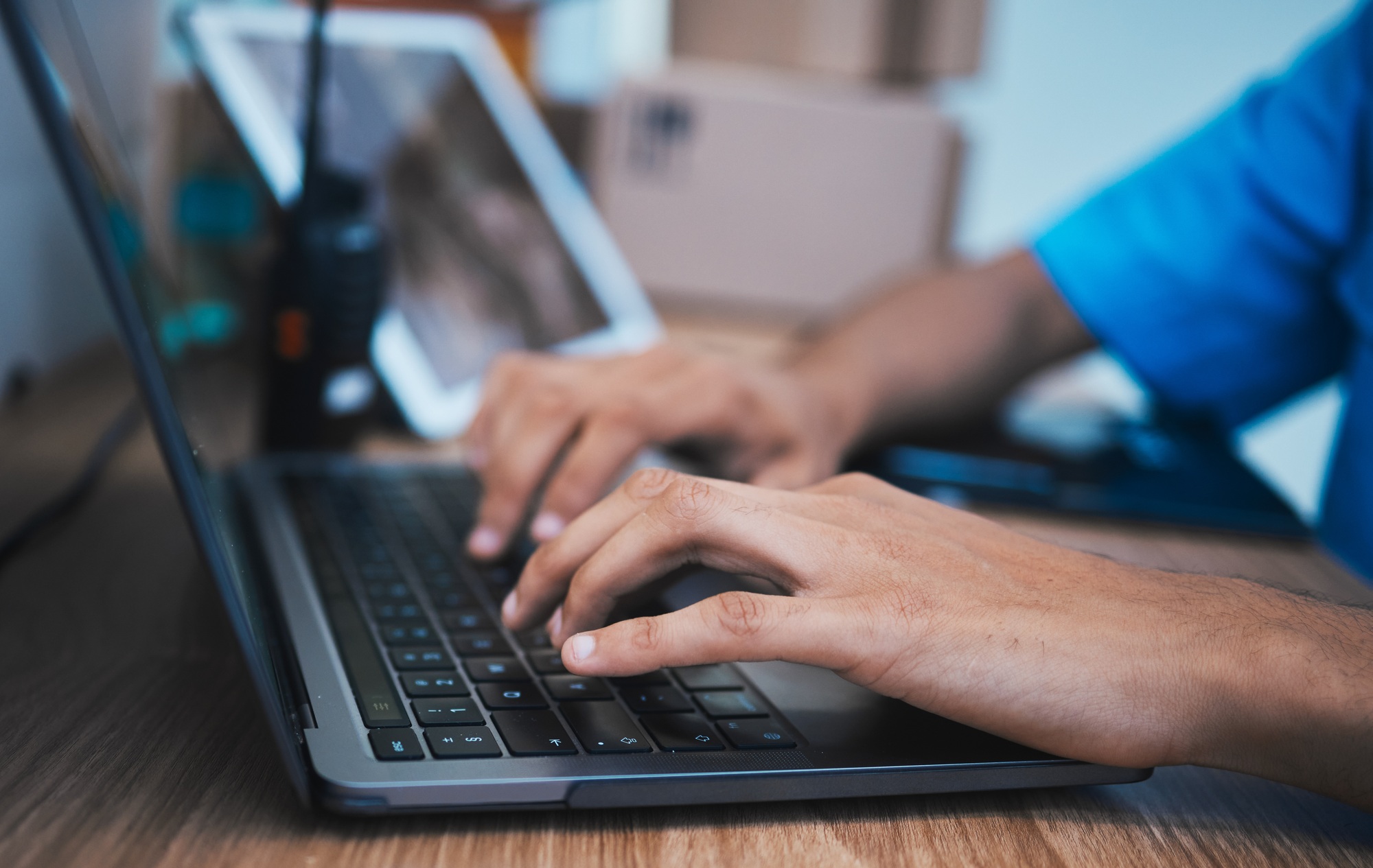 Hands, laptop and surveillance with a security guard in a CCTV room closeup to monitor criminal act